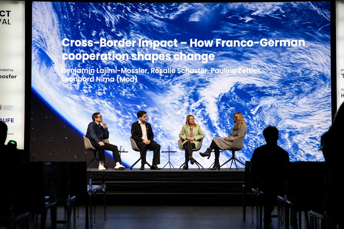 Zwei Geschäftspersonen stehen an einem Konferenztisch und die ien person schenkt der anderen ein Glas Wein ein