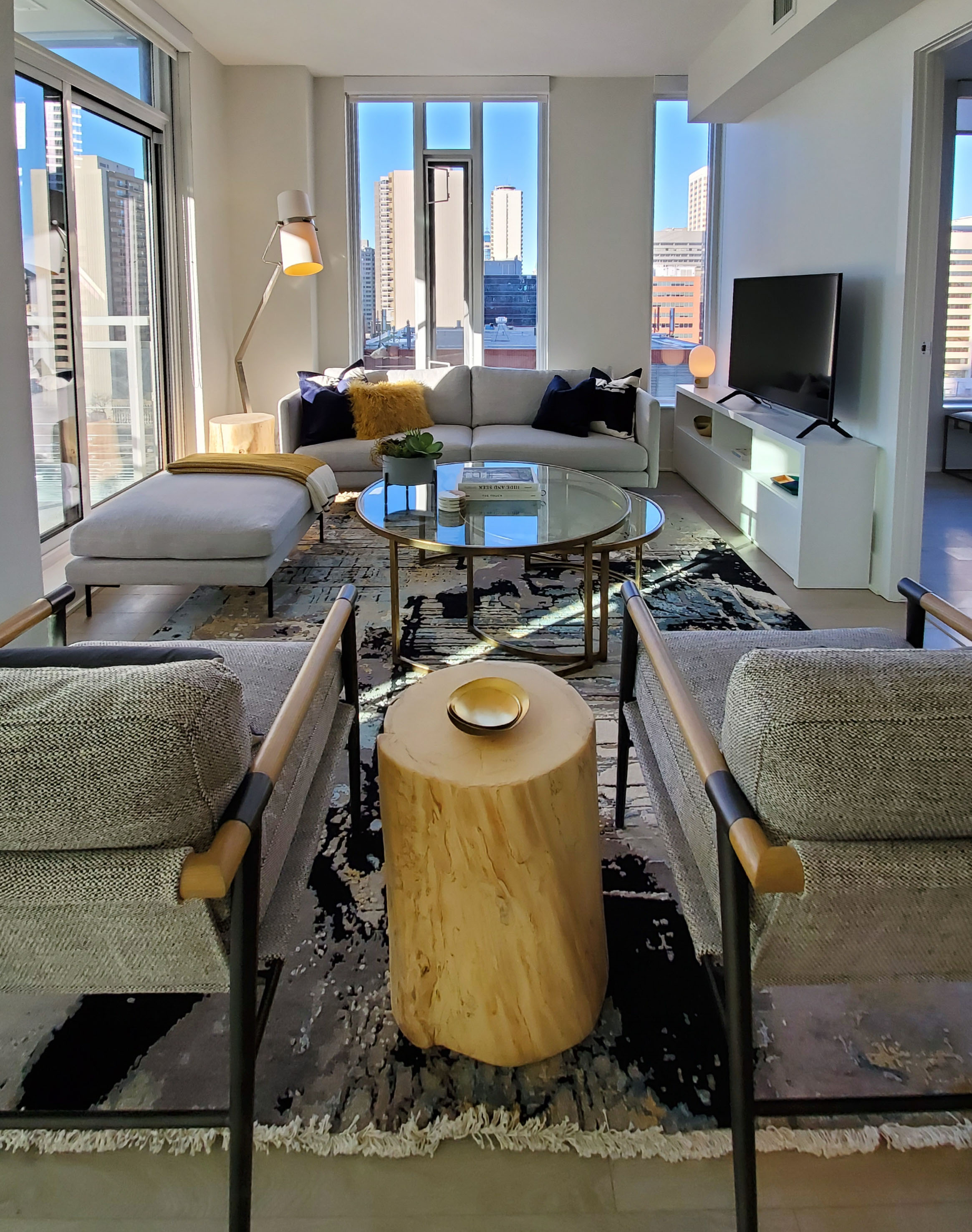 A living room with a wooden log being used as a side table between two arm chairs.