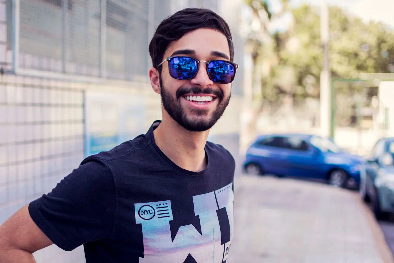 Man with beard and sunglasses smiling outdoors