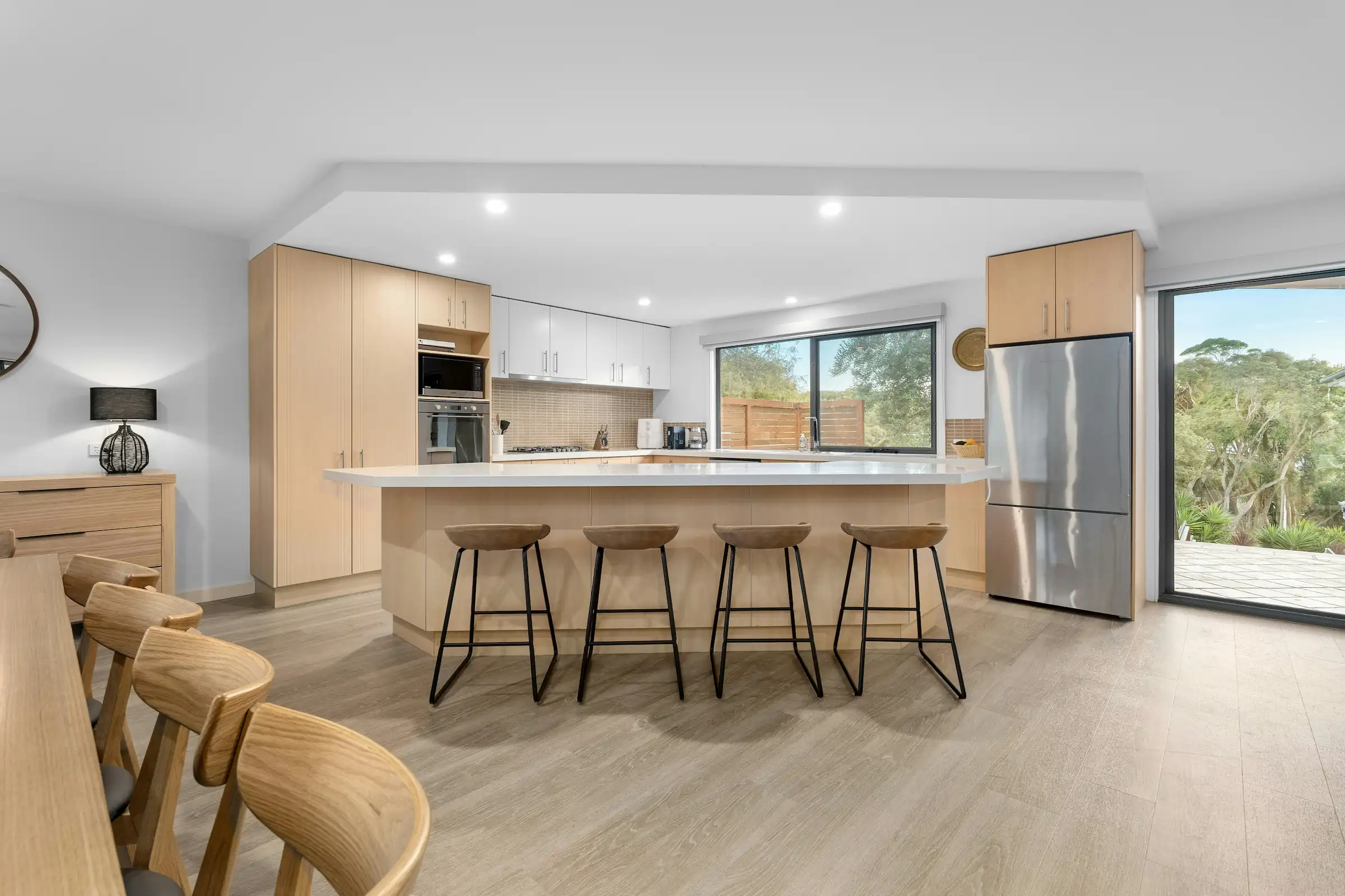 Modern interior entrance with floor-to-ceiling glass walls and warm timber cladding overlooking landscape