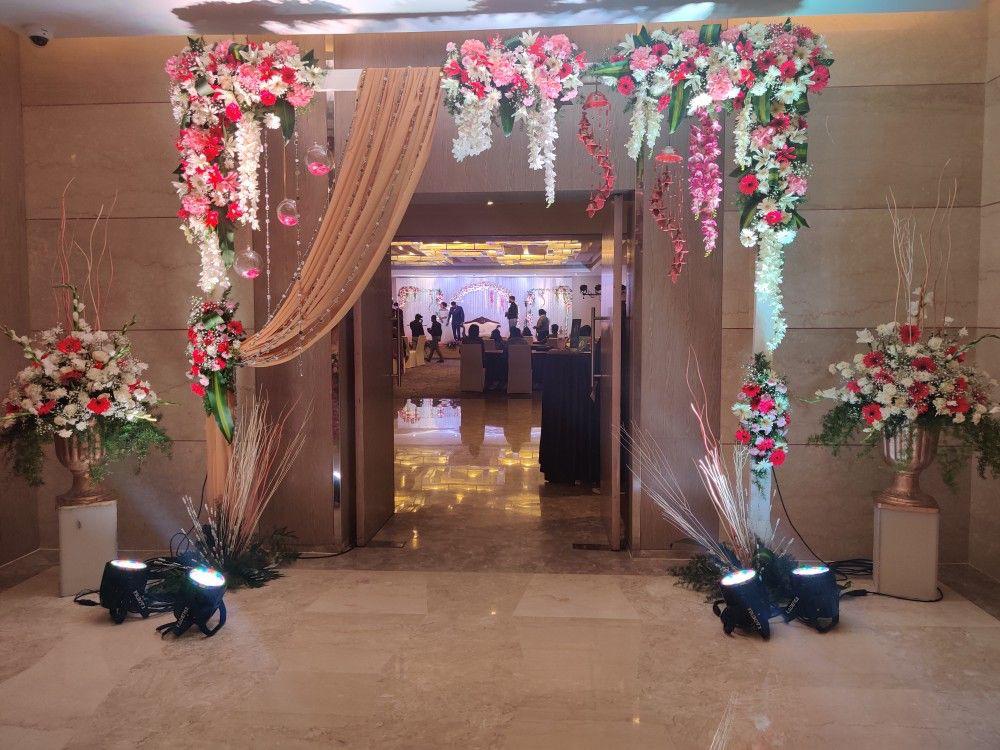 Banquet wedding entrance decorated with pink & white flowers & golden drape for grand gate decor in Tagore Garden & Ghaziabad
