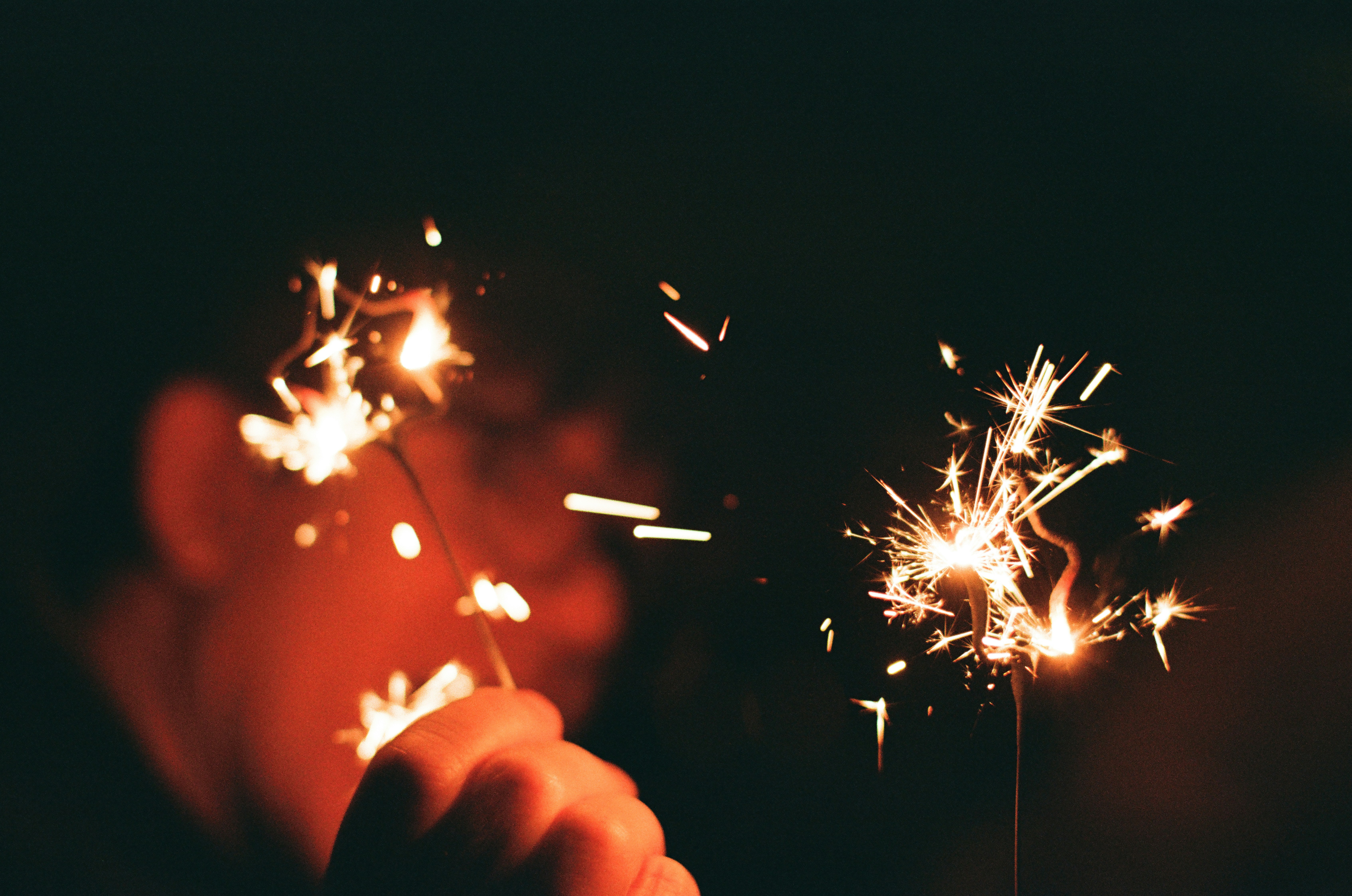 Sparklers burning brightly against a dark background.