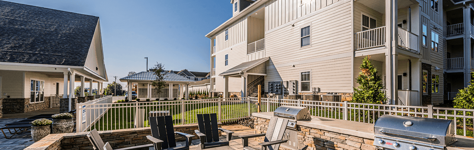 Outdoor BBQ and firepit area with grills and seating at The Reserve at Cool Springs, Elizabethtown, KY
