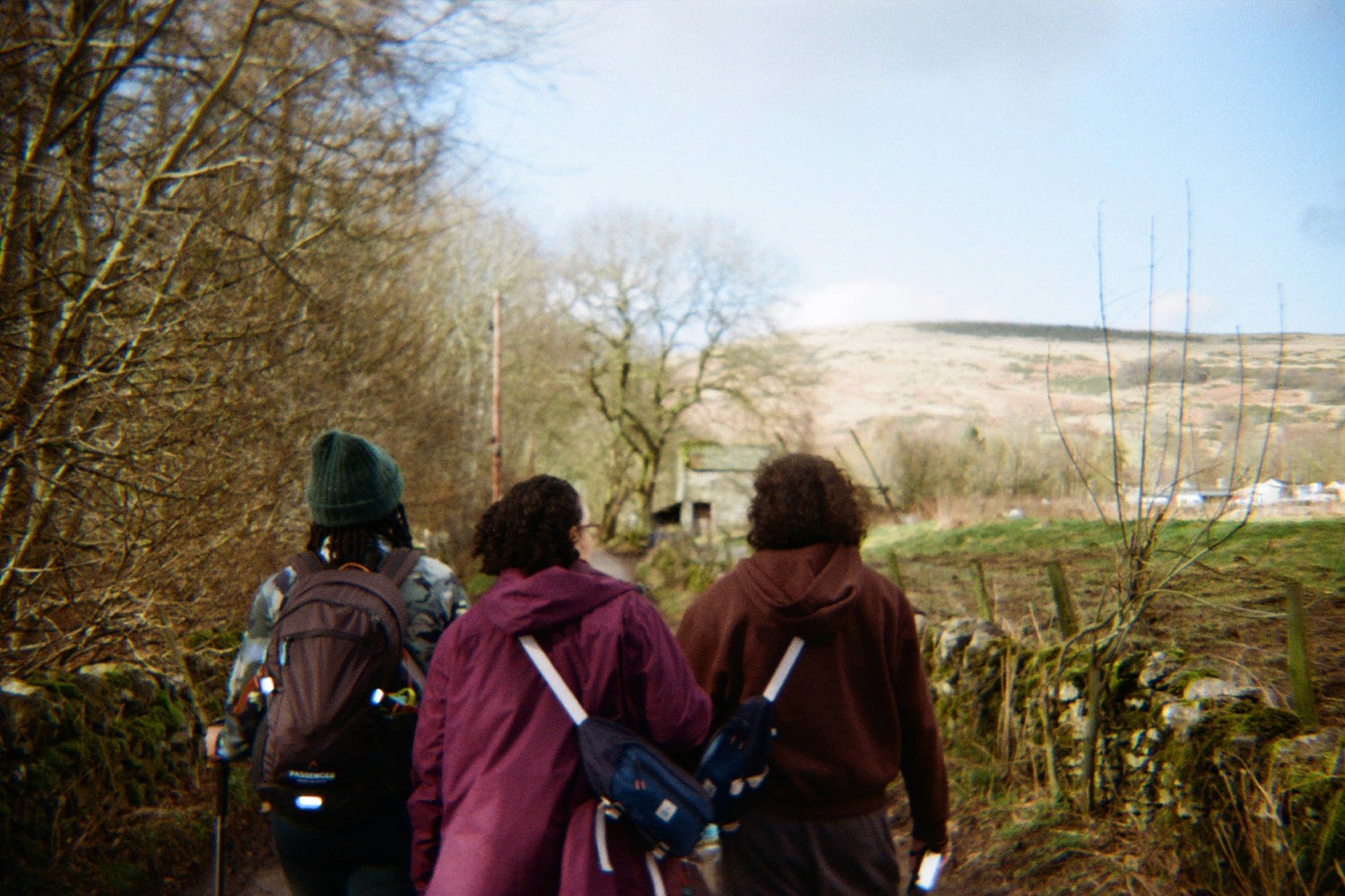 Three people walking away up a country path