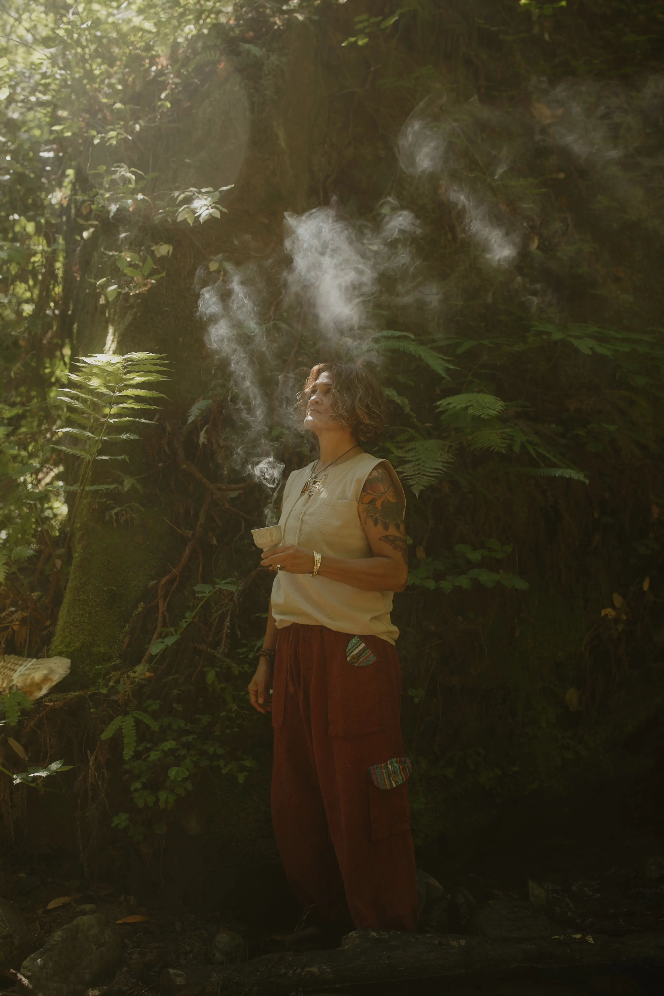 Woman in lush forest receiving psilocybin mushroom ceremony at Tree of Life Temple