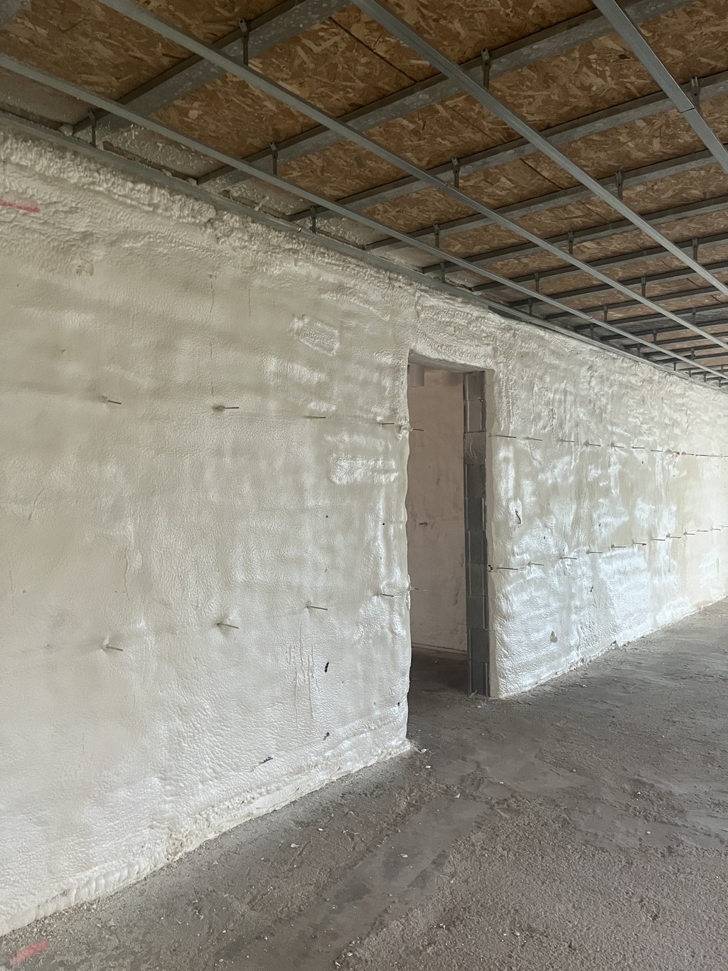 Plafond en cours d'isolation avec mousse de polyuréthane projetée, offrant une finition sans joint et robuste.