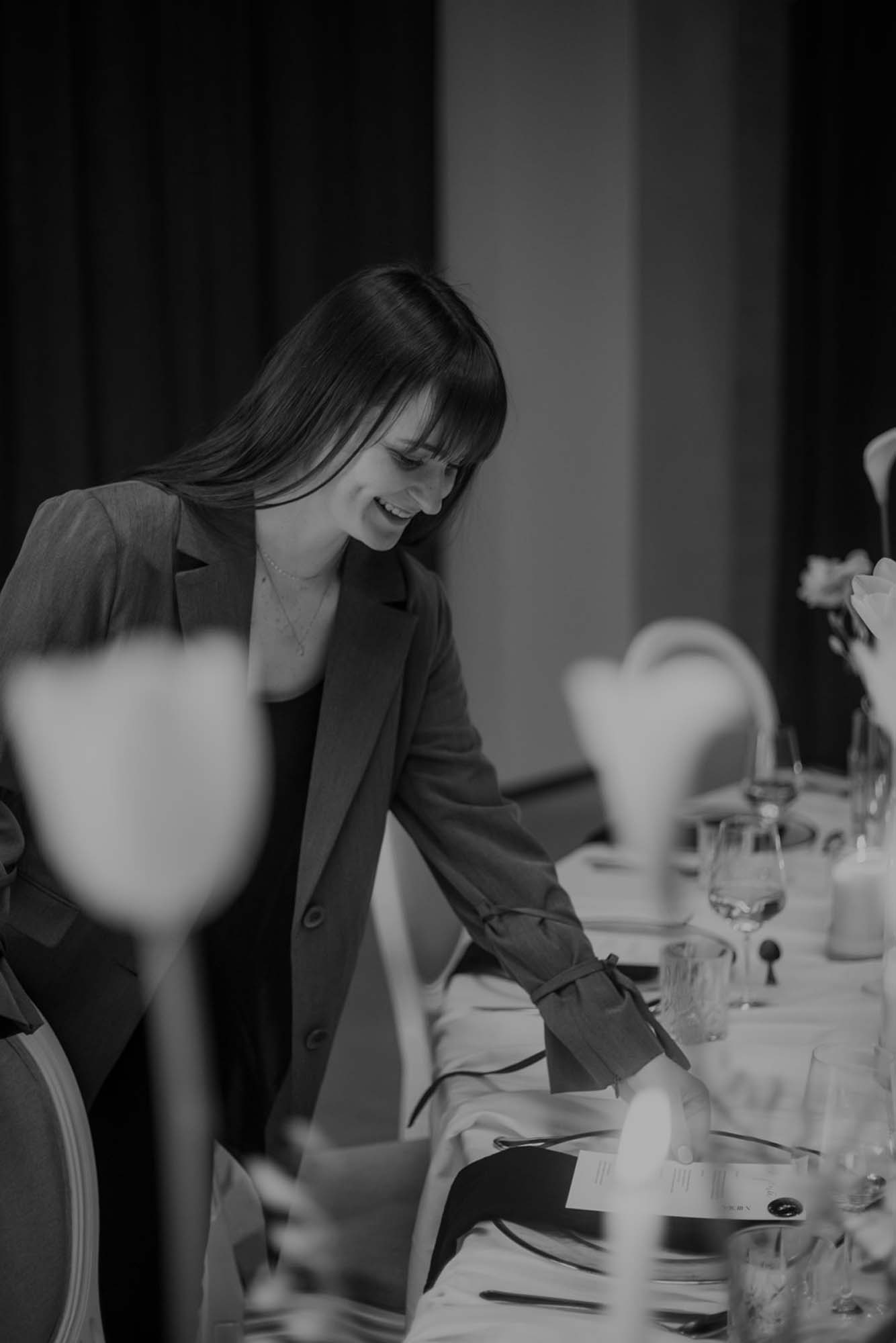 Hochzeitsplanerin Emily richtet die Dekoration auf einem Tisch.