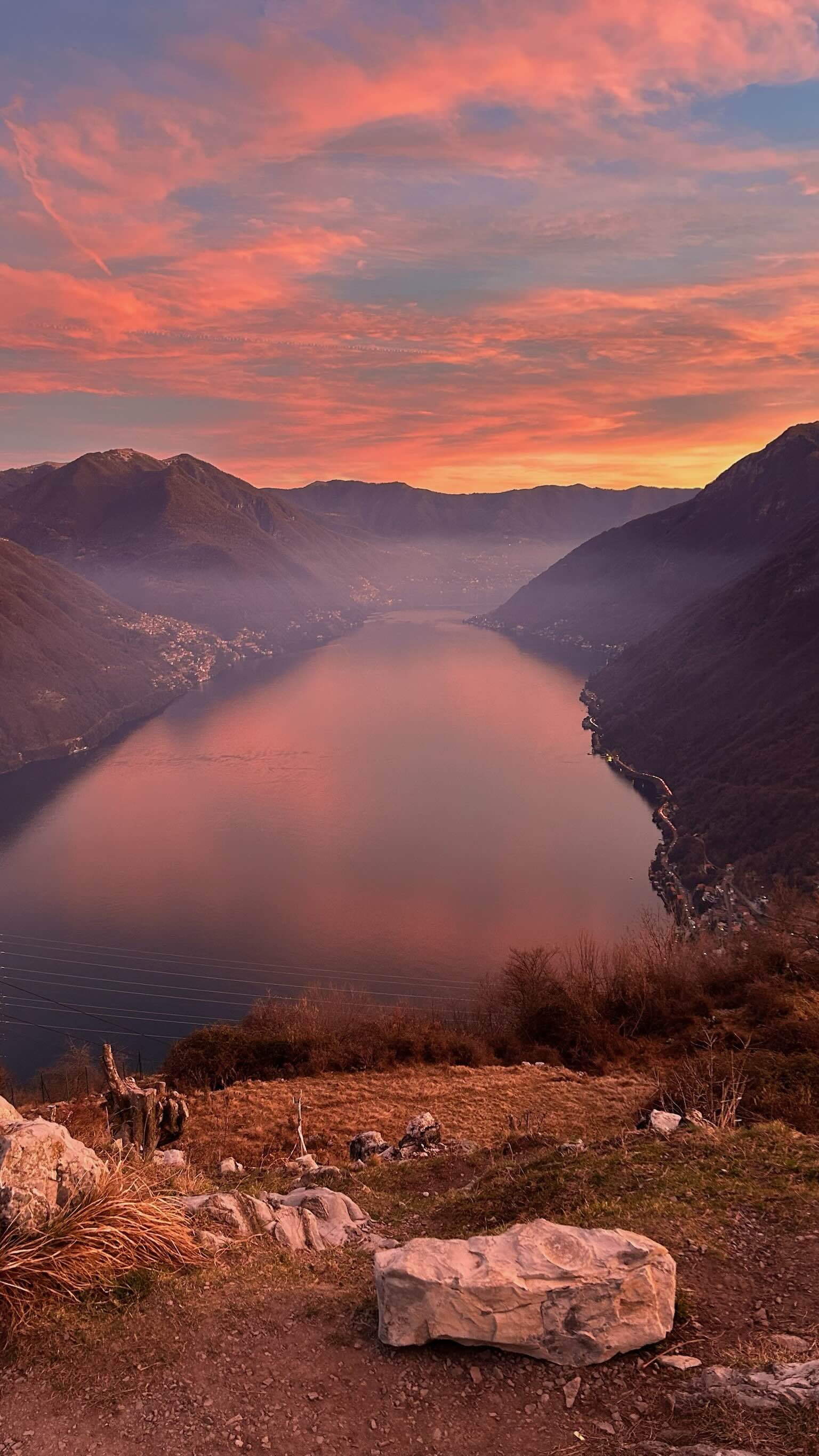 Lake Como seen from above at sunset with fog and pink colours