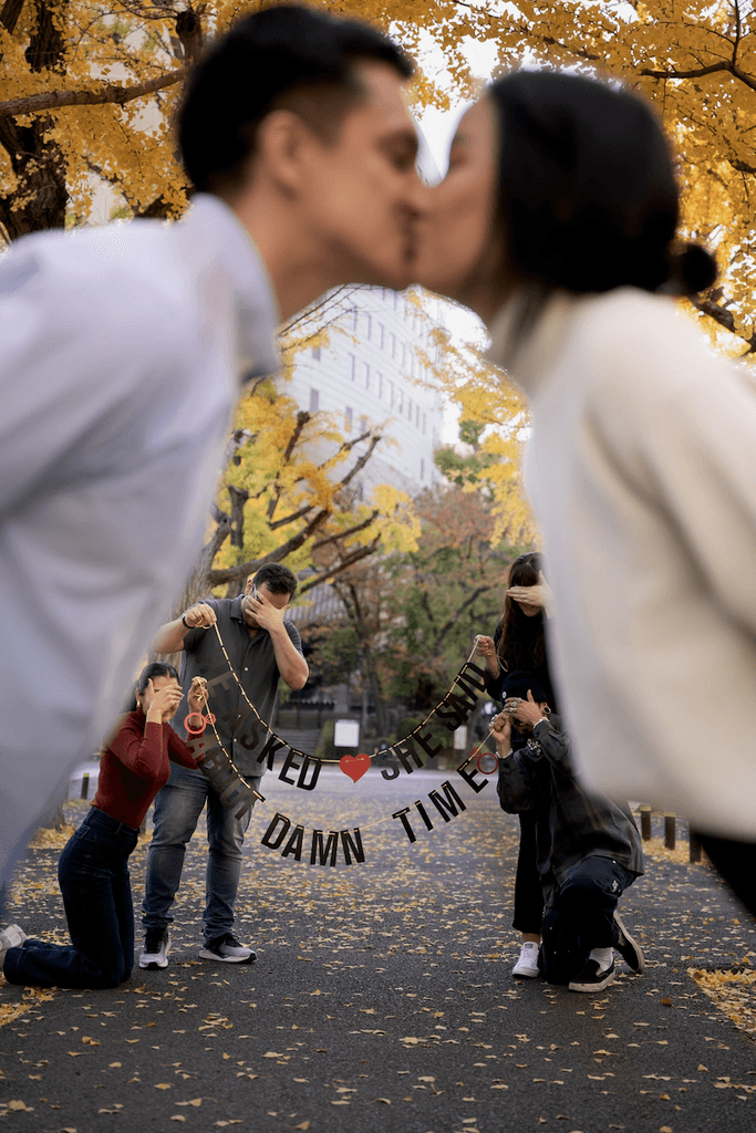 Couple kissing with friends in the background