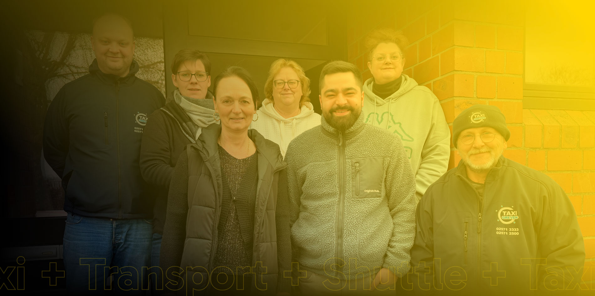 Das gesamte Team des Taxiunternehmens posiert vor der Kamera.