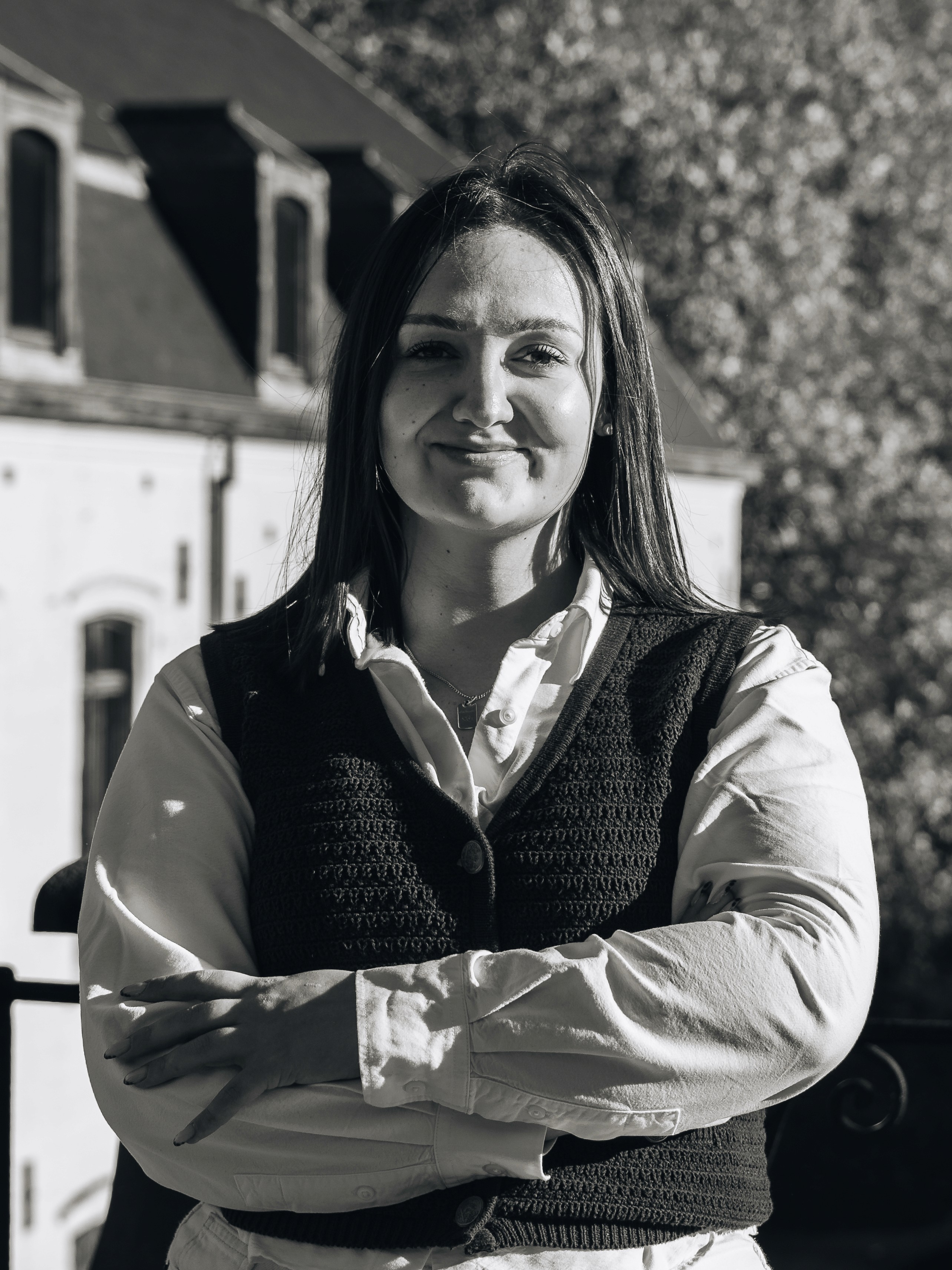 Portrait of a laughing person with curly hair wearing a white shirt