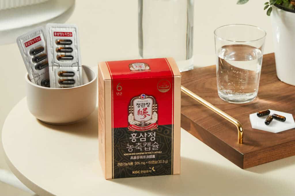 Hộp 정관장 홍삼정 농축캡슐 cùng viên nang và ly nước