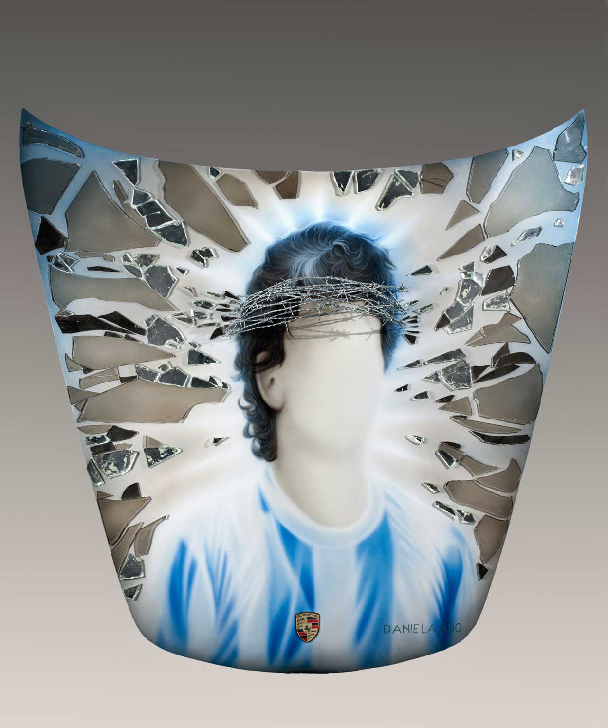 Obra de Daniela Boo elegida para estar sobre el Porsche en la 1era muestra de arte del Museo de Porsche en Stuttgart -Stuttgart Porsche Museum – Messi Maradona. Vidrios y espejos rotos y alambre de púas para retratar al idolo del football Argentino.