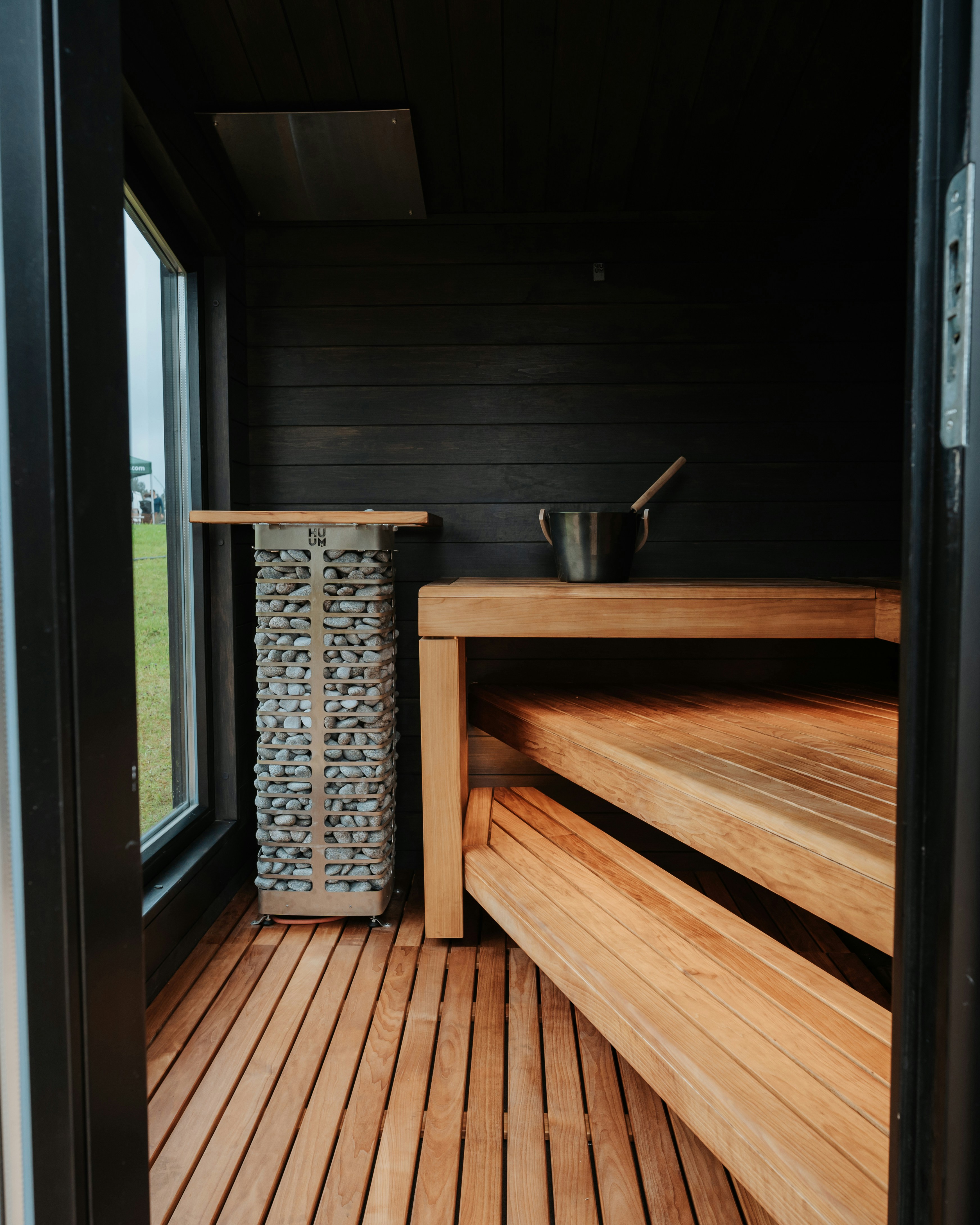 Interior of a modern wooden sauna with stone heater.