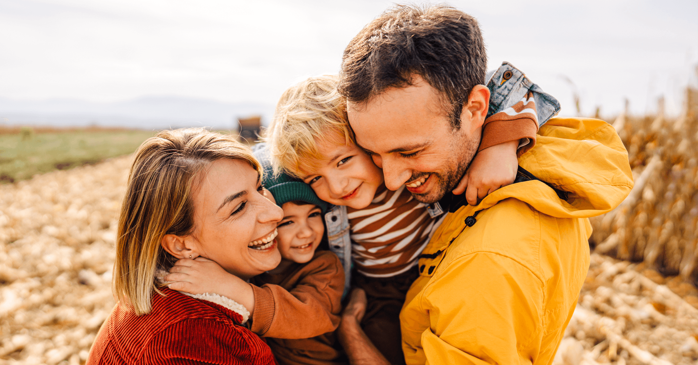 En mor och en far tillsammans med deras två söner på en äng.