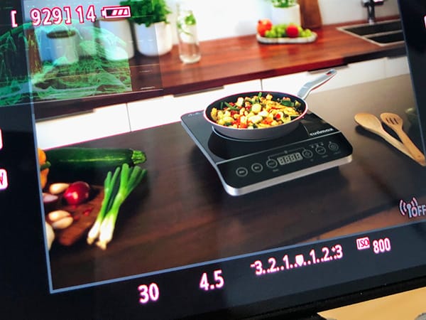The camera monitor shows the kitchen equipment being filmed