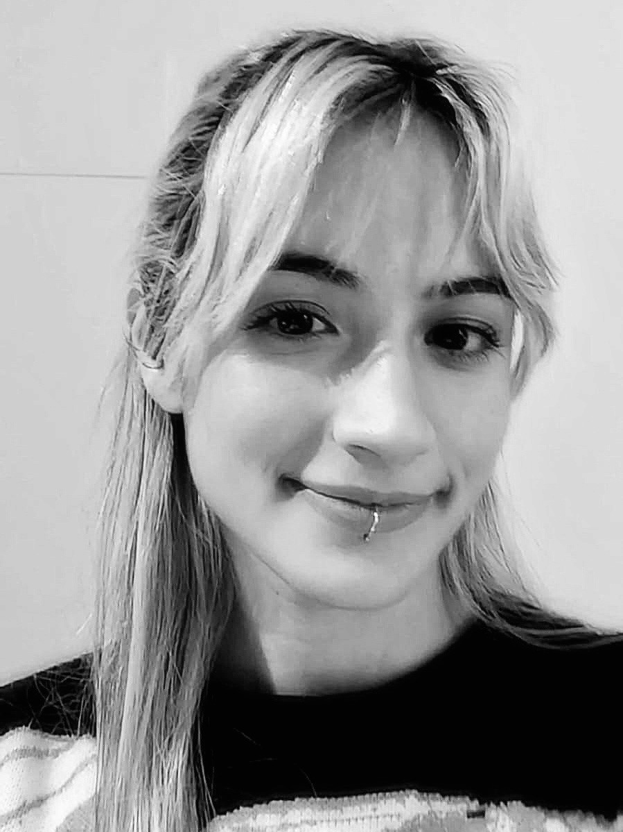 Retrato blanco y negro de mujer con pelo claro liso y fleco, con un piercing en el labio inferior