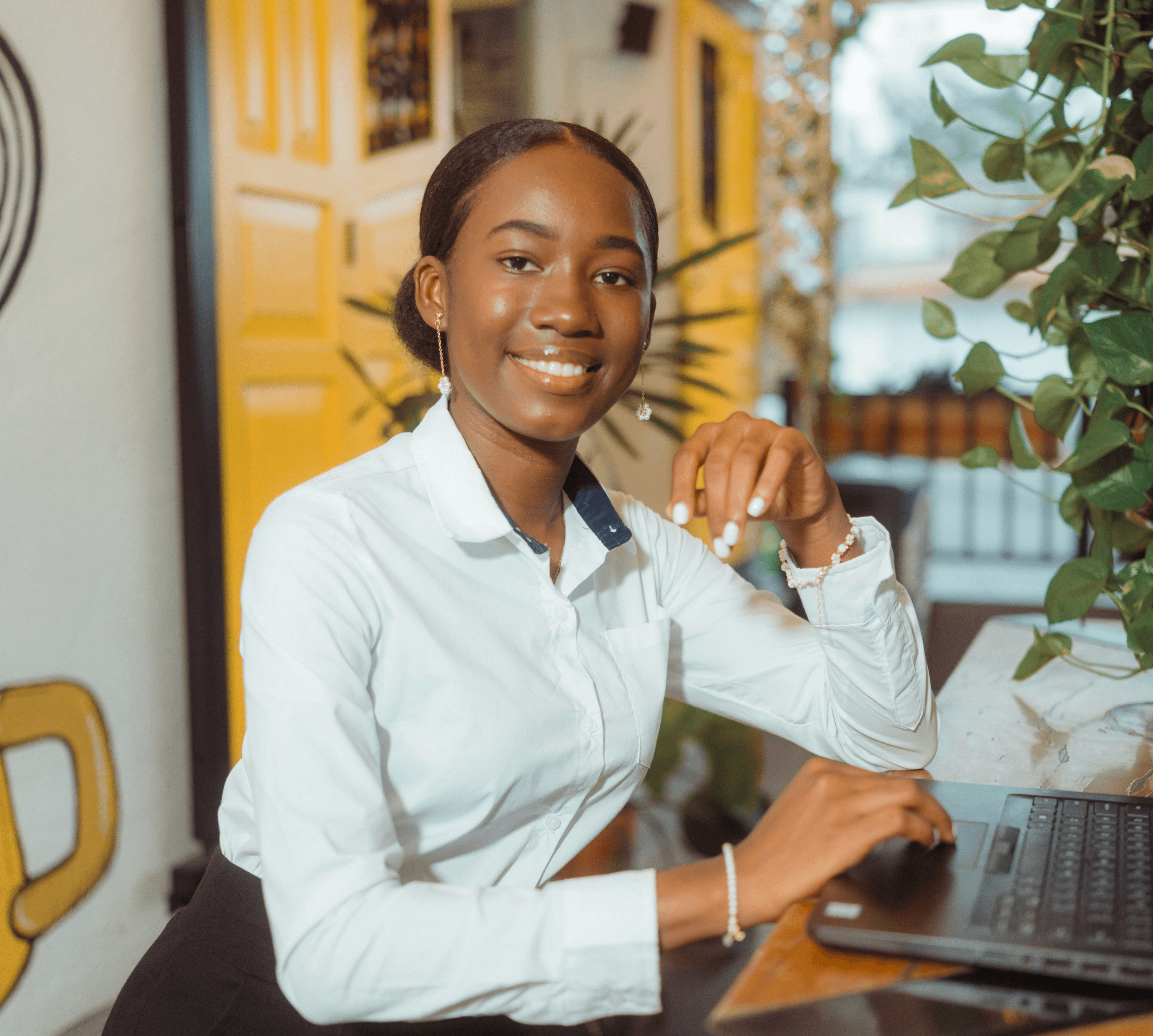 Young woman smiling at desk with laptop.