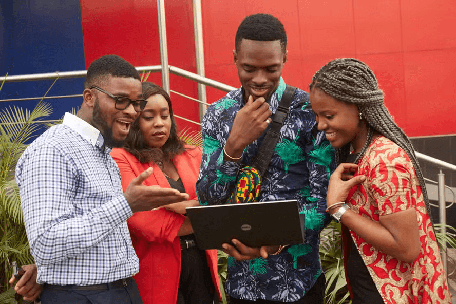 4 pessoas pretas ao redor de um notebook