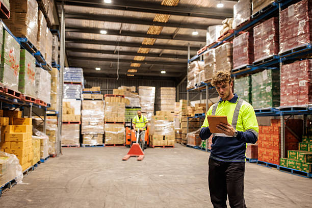 image of two people wearing high vis protection gear one is checking a clip board the other is operating a pump truck