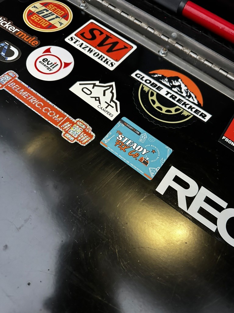 A sticker from The Steady Fix Co. amongst overlanding brand decals 