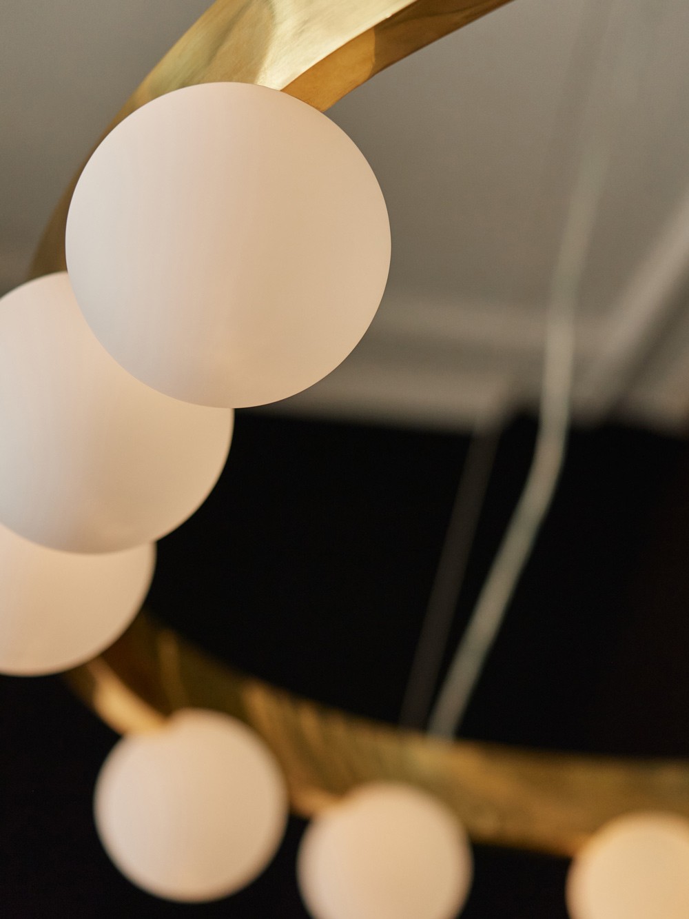 Cami chandelier close up– brass ring with frosted glass globes for soft ambient lighting