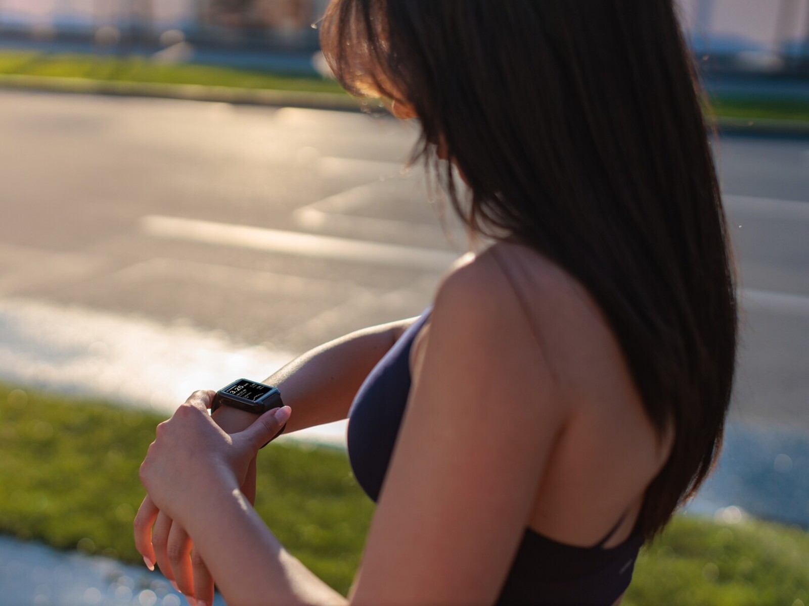 woman checking her smart watch to see how many miles a day to lose weight she has to g