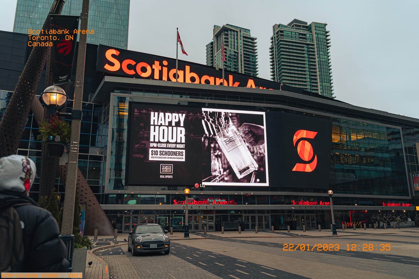Façade de la Scotiabank Arena à Toronto avec un grand écran publicitaire et des immeubles en arrière-plan.