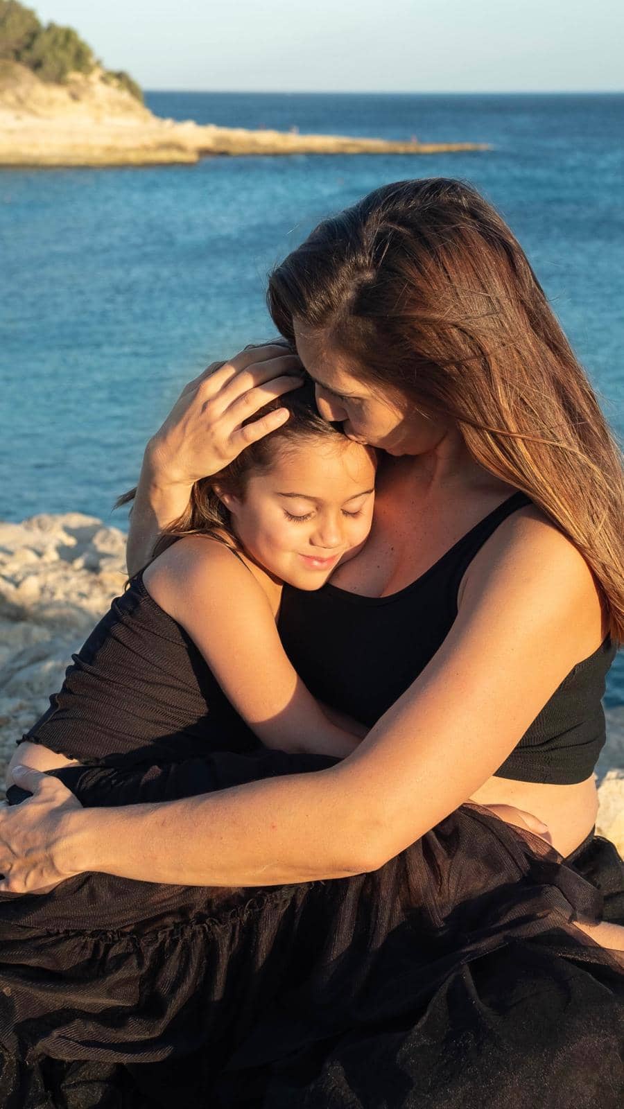Photographie d’une future maman lors d’un shooting grossesse, accompagnée de son enfant : une idée cadeau pleine d’émotion pour femme enceinte.