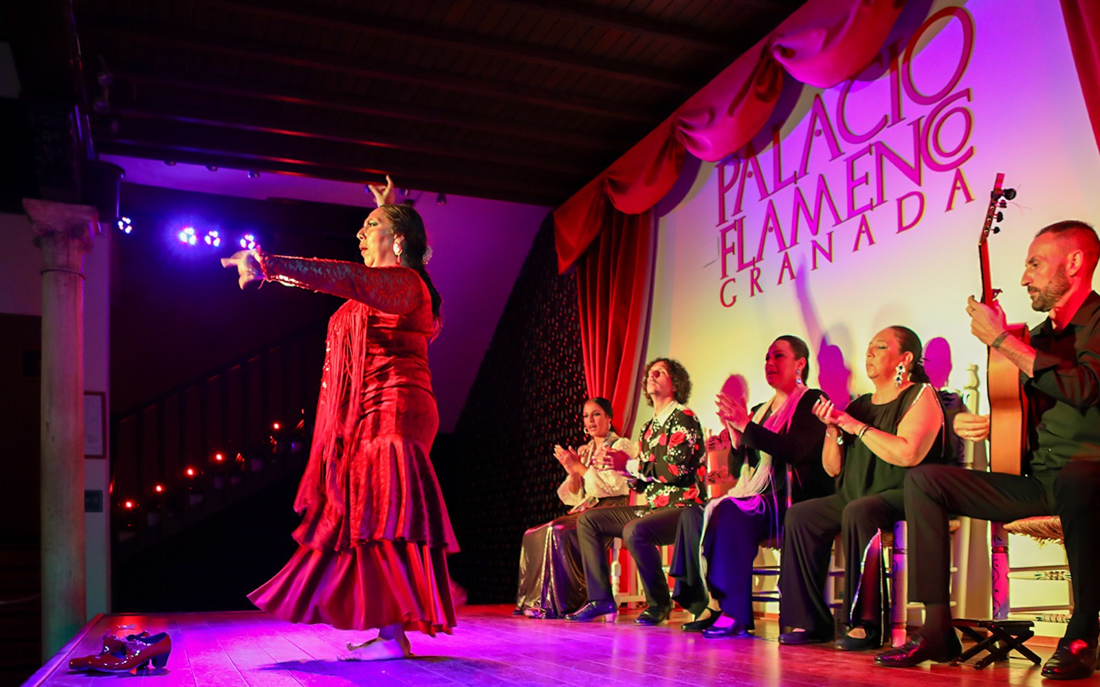Flamenco-danser opptrer på Palacio de los Olvidados, Granada, med musikere og publikum.