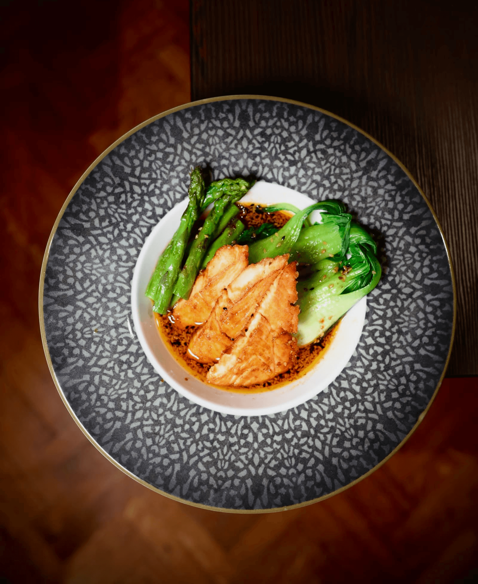 Gebratenes Hähnchen mit Spargel und Bok Choy. Leckeres Gericht auf dekorativem Teller. 