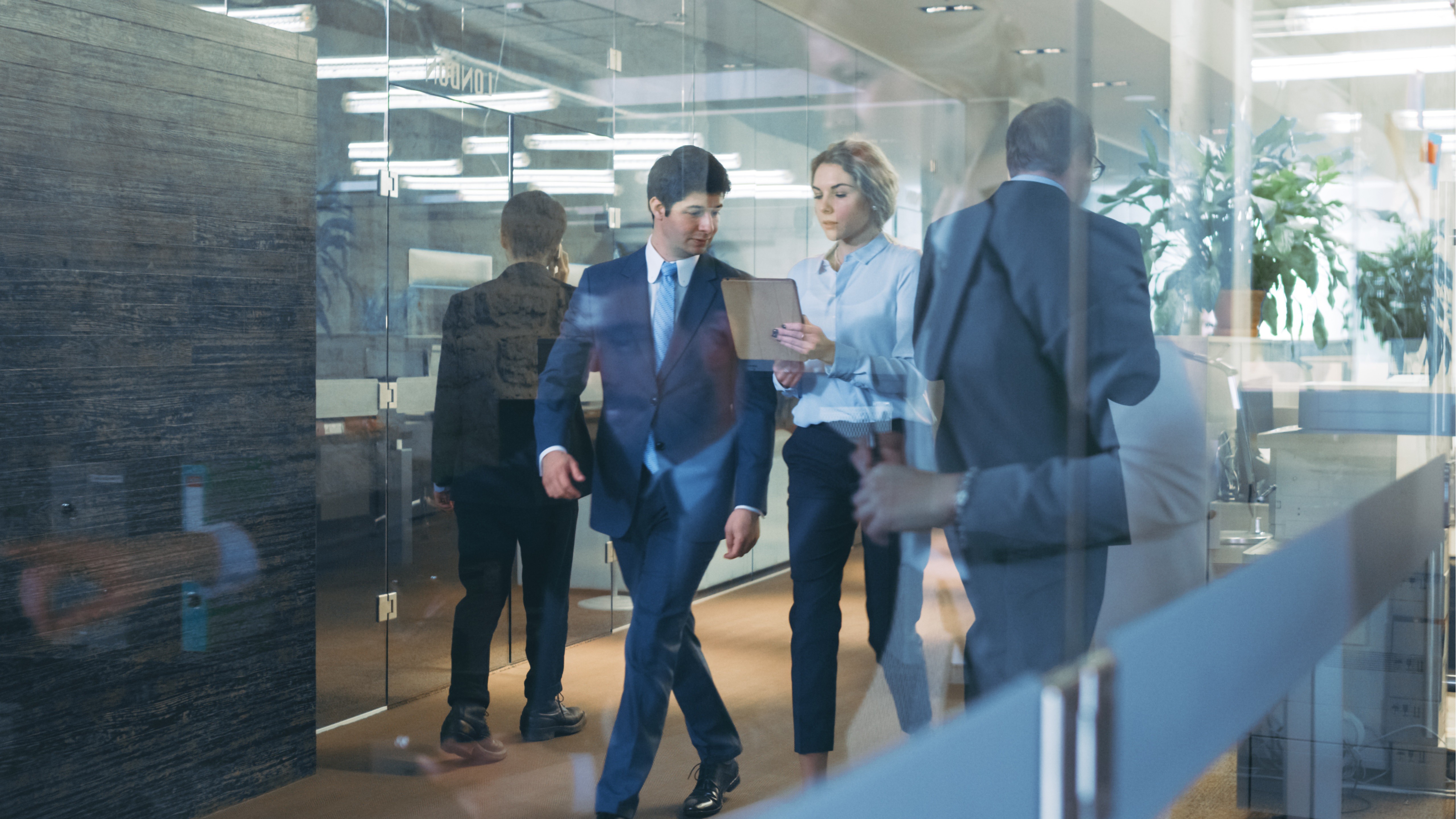 Audit-Team bespricht einen Audit-Plan im Büroflur und überprüft Dokumente, um den Umfang des Audits, die Anforderungen an die Nachweise und einen fokussierten Audit-Ansatz vor der Durchführung zu definieren.