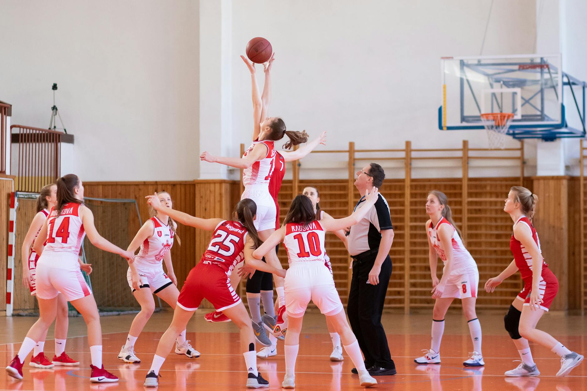 A high school student jumping to block a volleyball at the net during a competitive team sports unit.