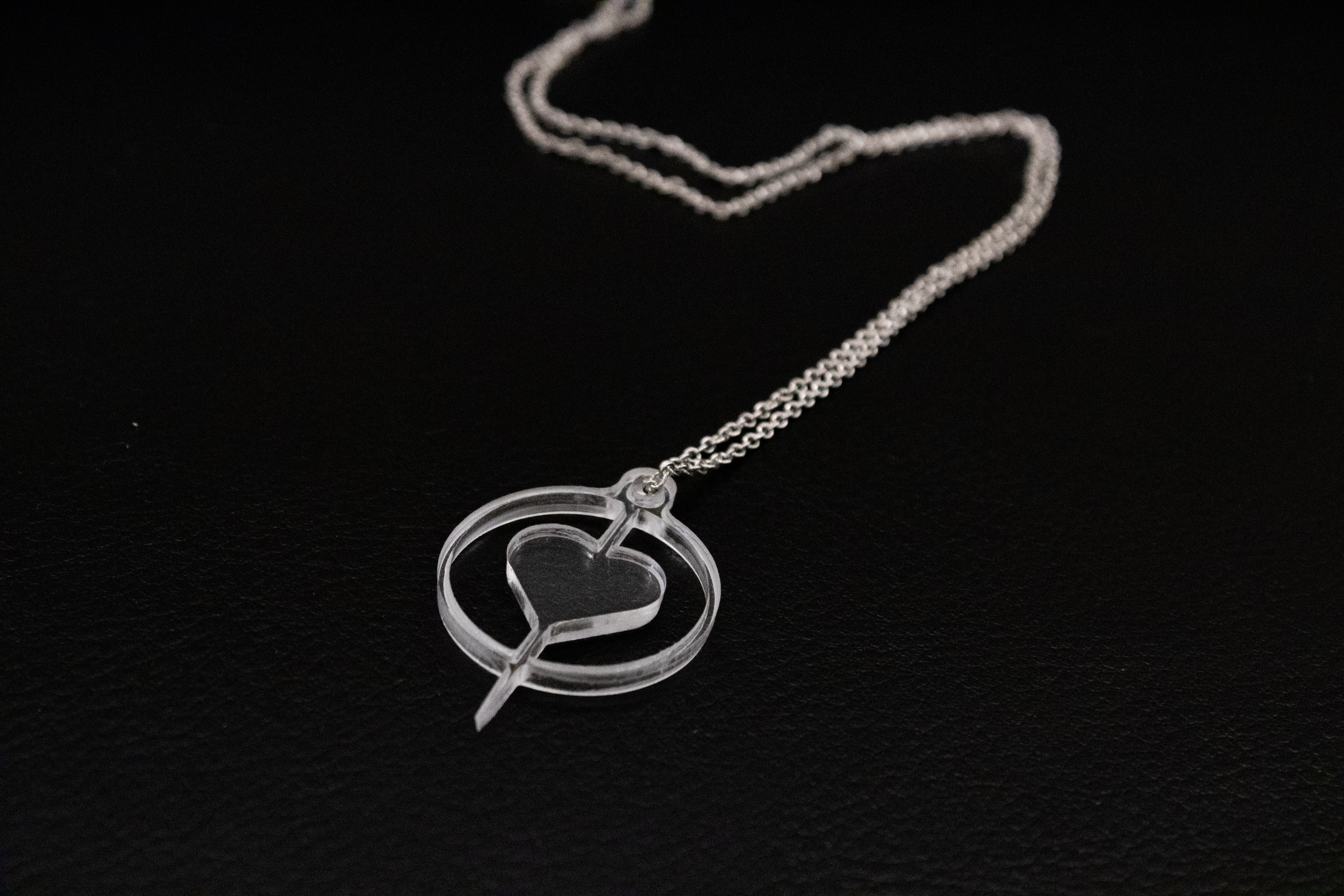 close up shot of promotional item: a heart shaped necklace with a sharp point