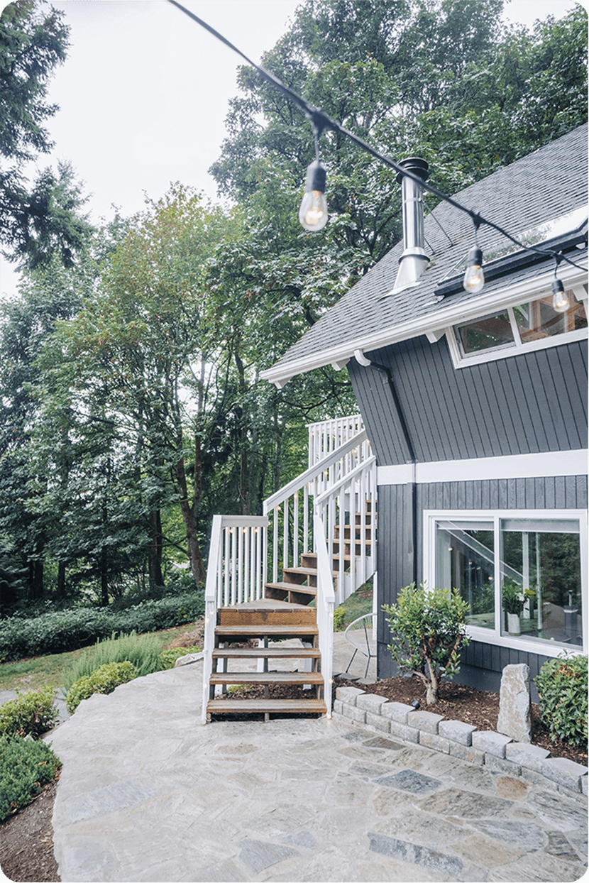Modern marble shower featuring large format tiles, brass rainfall showerhead, handheld sprayer, and built-in seating bench
