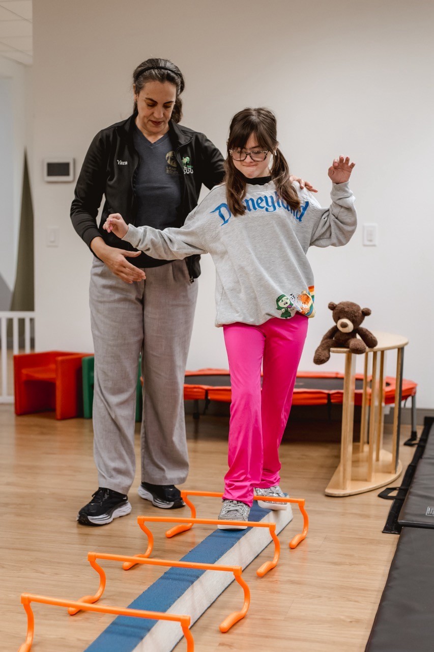 Child with disabilities practicing balance with therapist at Norco pediatric clinic.