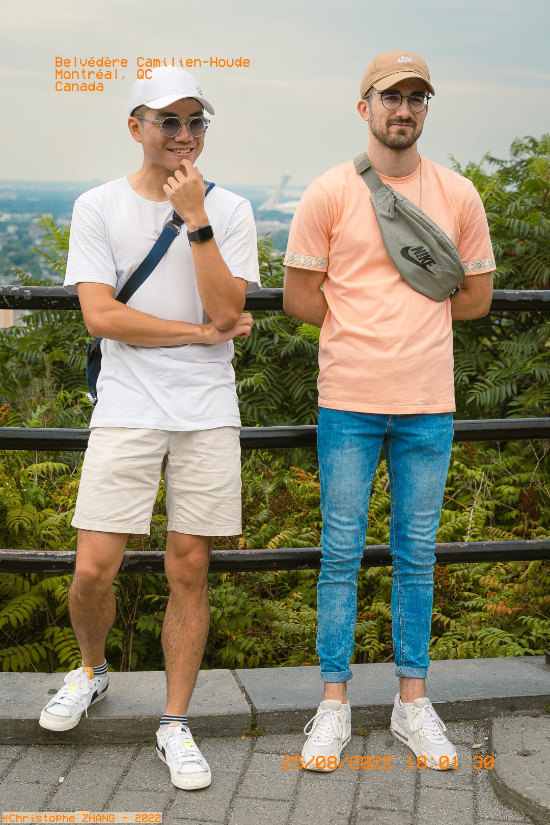 Deux amis posant devant le Belvédère Camillien-Houde, avec Montréal en arrière-plan.