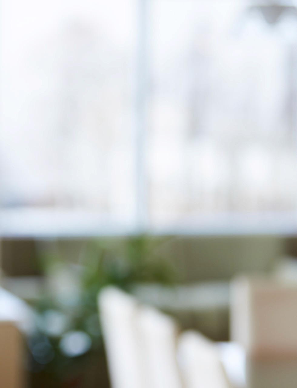 Blurry image of a white wall next to an orange wall.  A shelf with small white objects is visible.