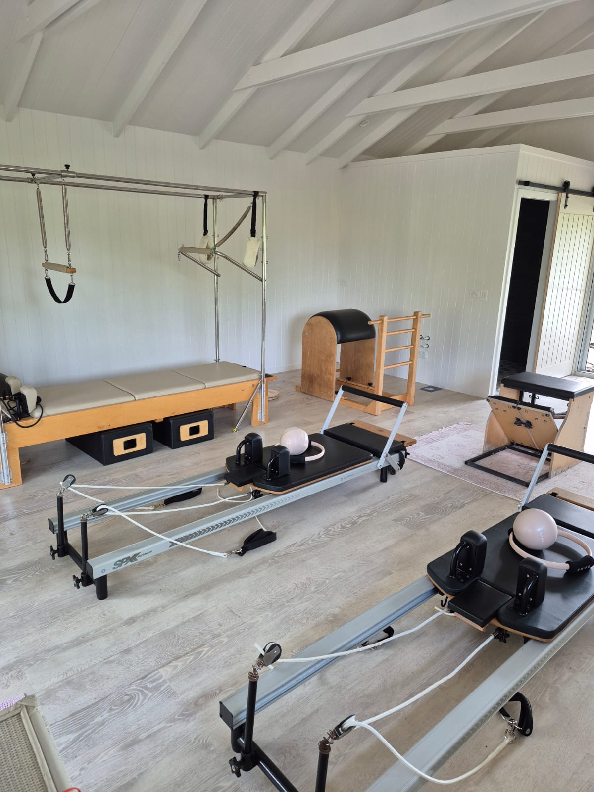 Bright Pilates studio interior with reformers and classical apparatus at The Honey Homestead, Piggabean.