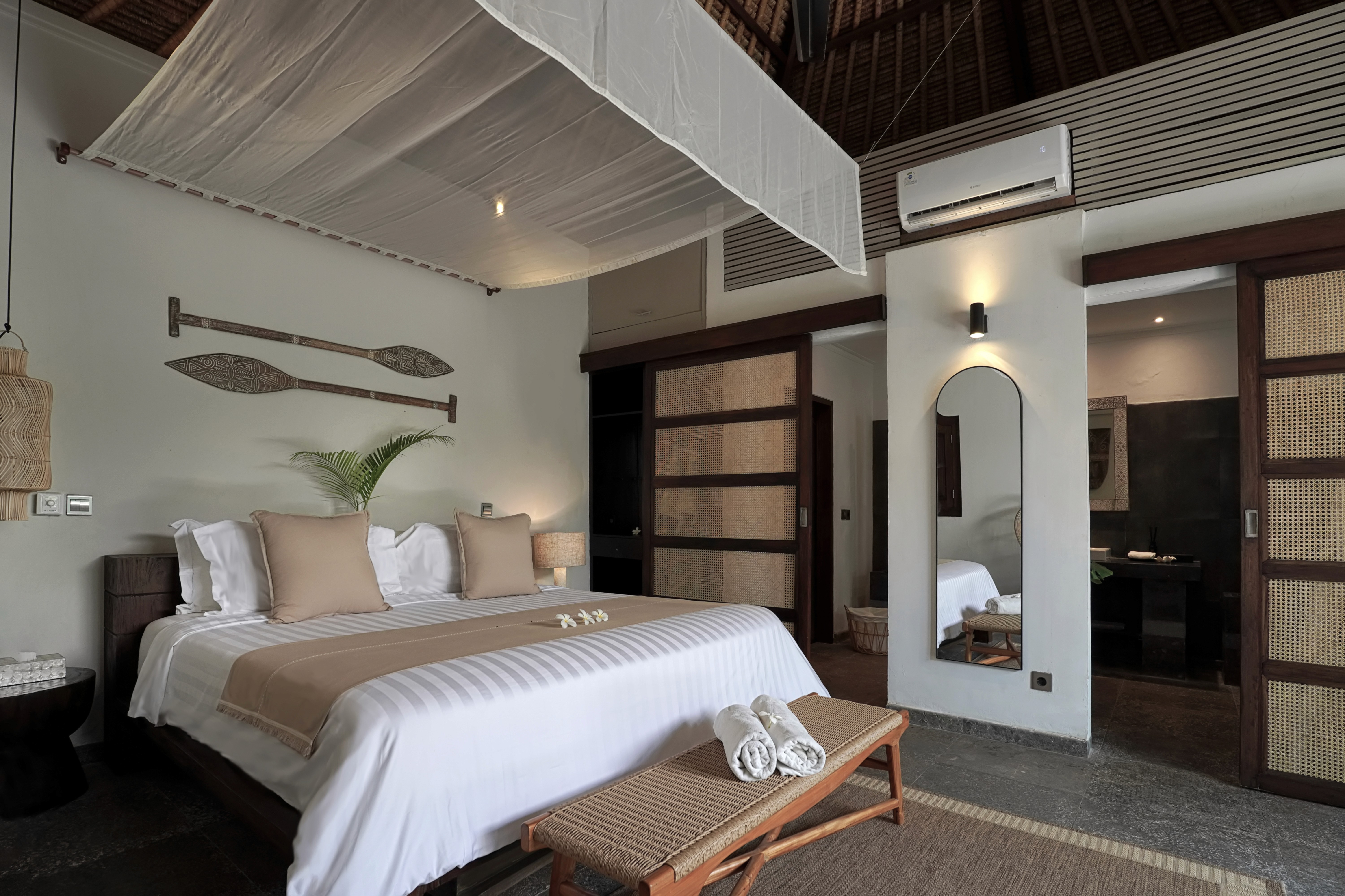 A serene garden-view hotel suite with private patio surrounded by tropical plants
