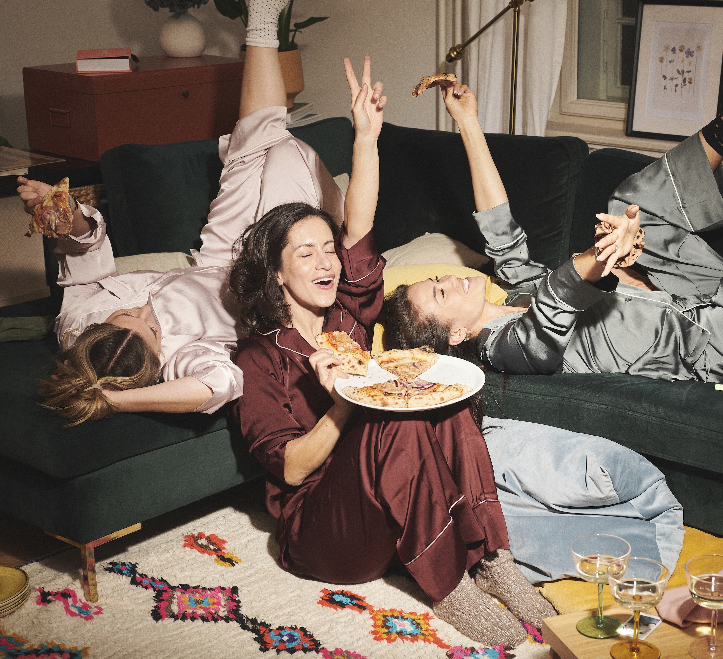 Dynamic close-up of a runner’s foot mid-stride on a muddy forest trail, wearing black socks and red trail shoes with visible sole pattern.