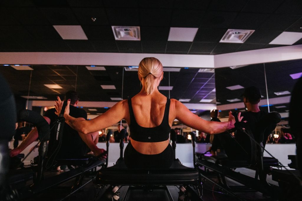 Kobieta w czasie treningu lagree na maszynie megaformer.