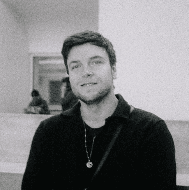Man with styled hair and beard wearing black shirt.