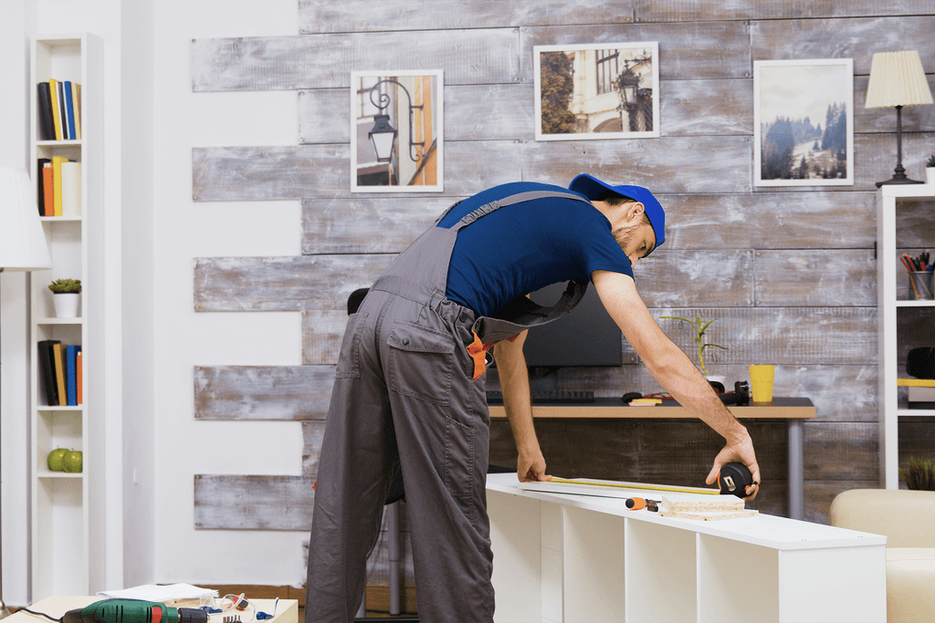 Montaža nameštaja u dnevnoj sobi – profesionalni radnik precizno meri i sklapa elemente