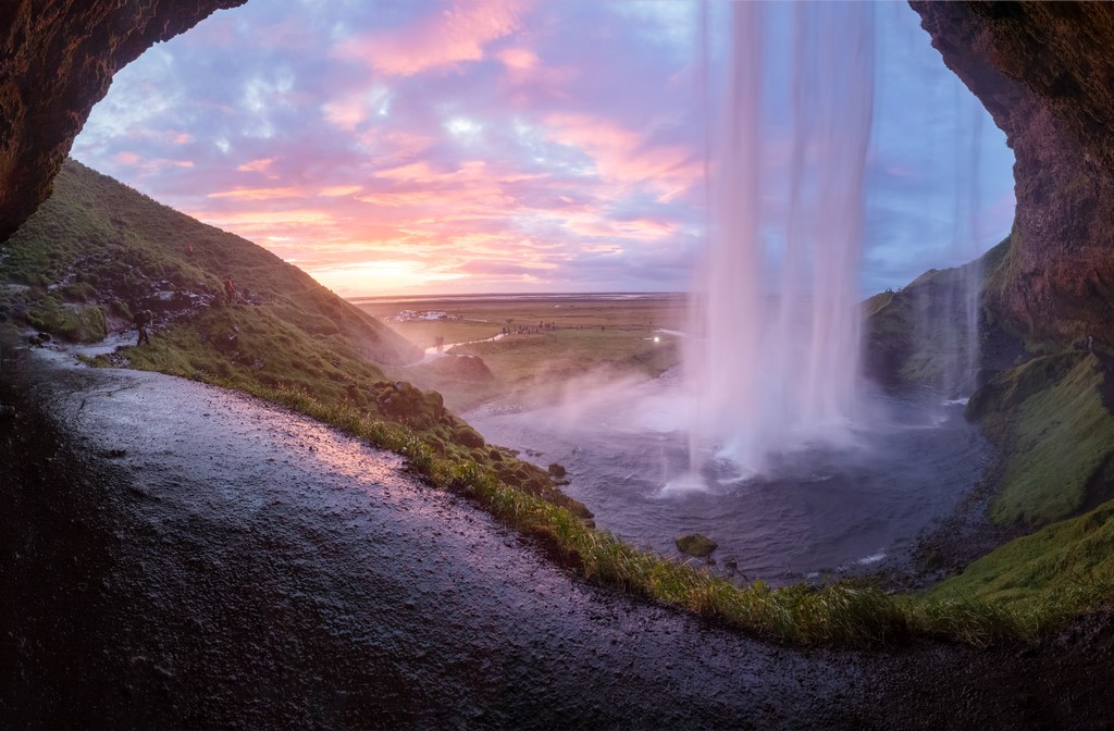 A waterfall surrounded by grass and rock formations