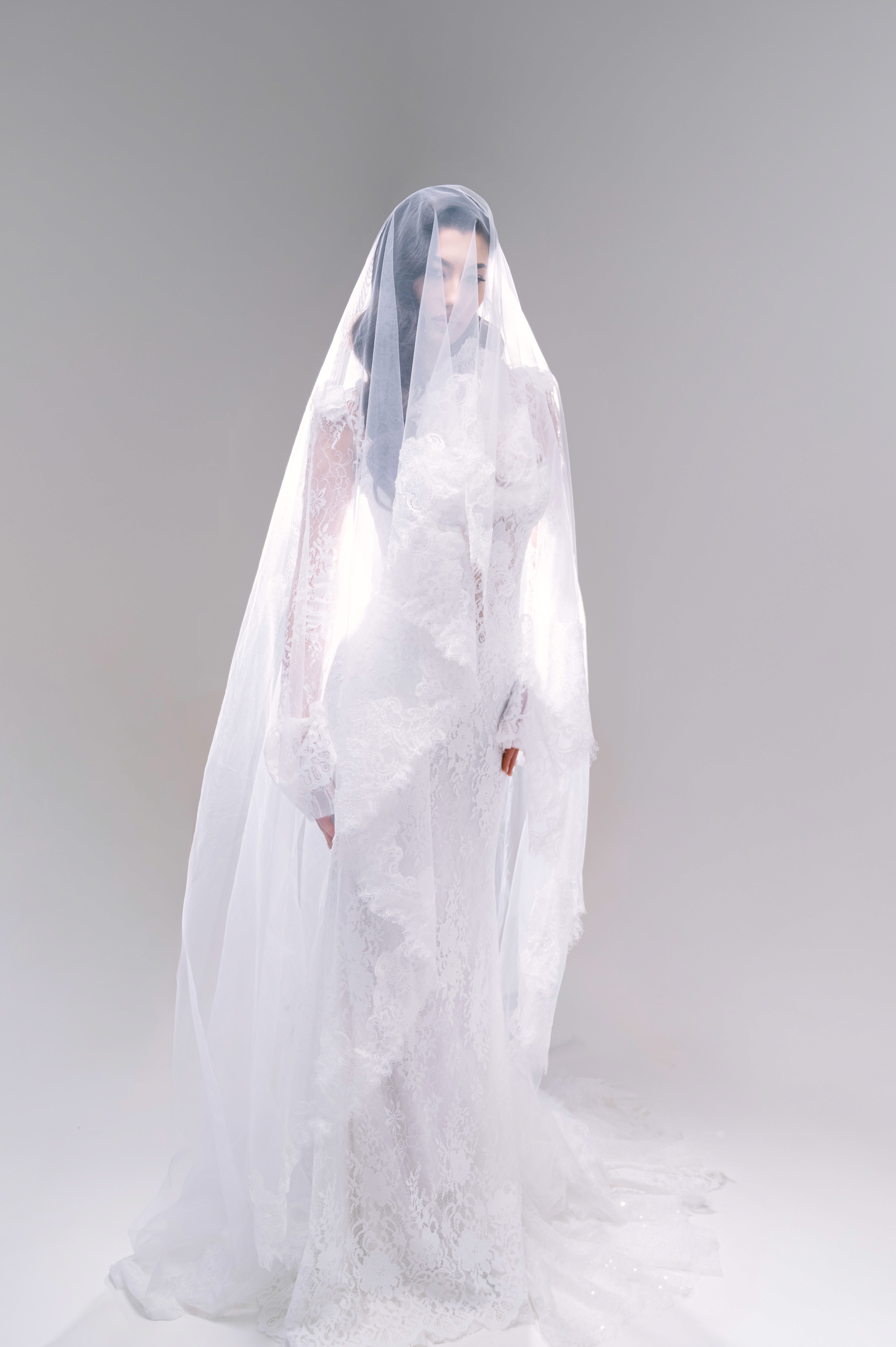 Mireasă fotografiată prin voal într-un decor luminos și minimalist, ședință foto bridal în București