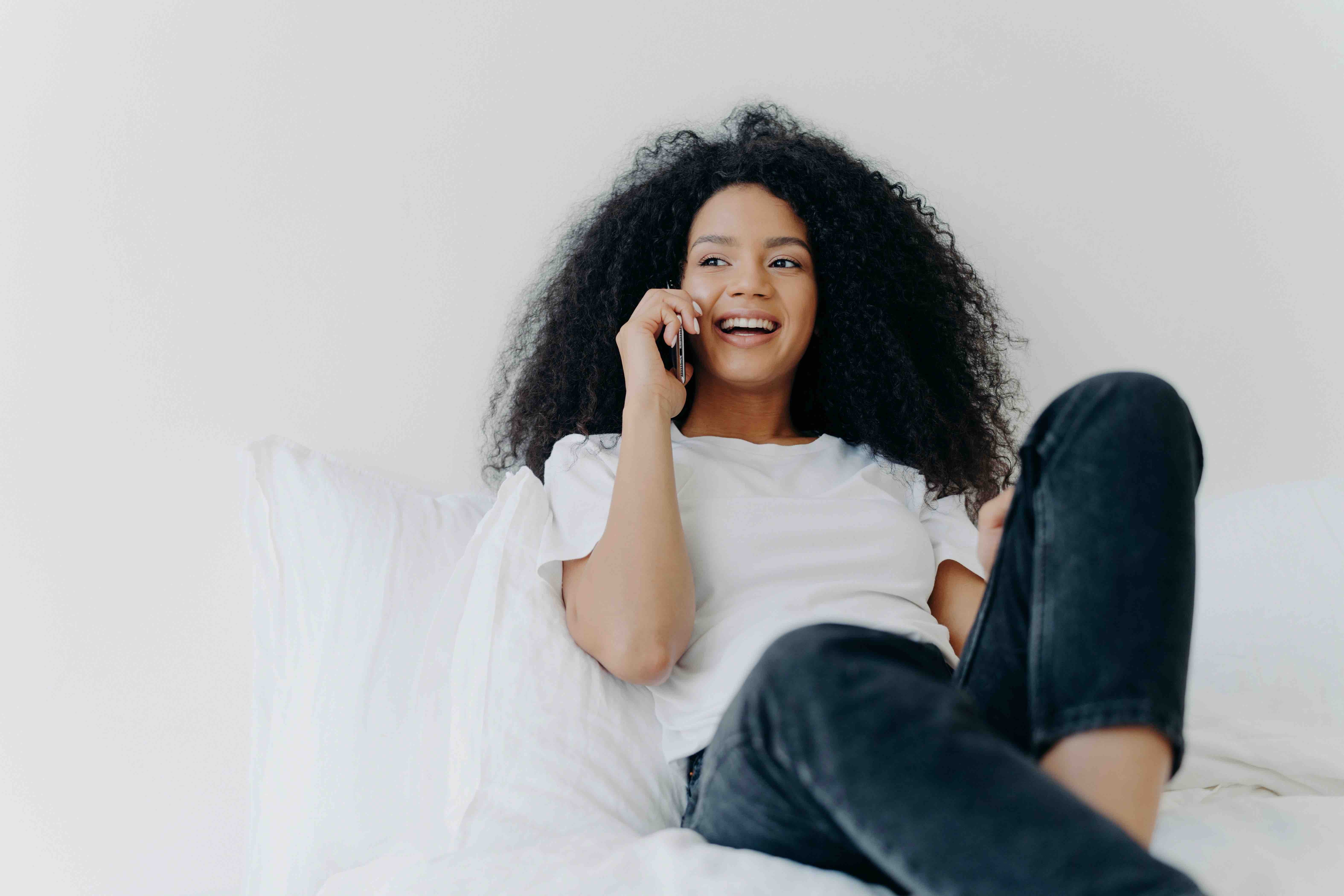 Curly haired women talking on her cellphone using Journey Japan eSIM data plan for service