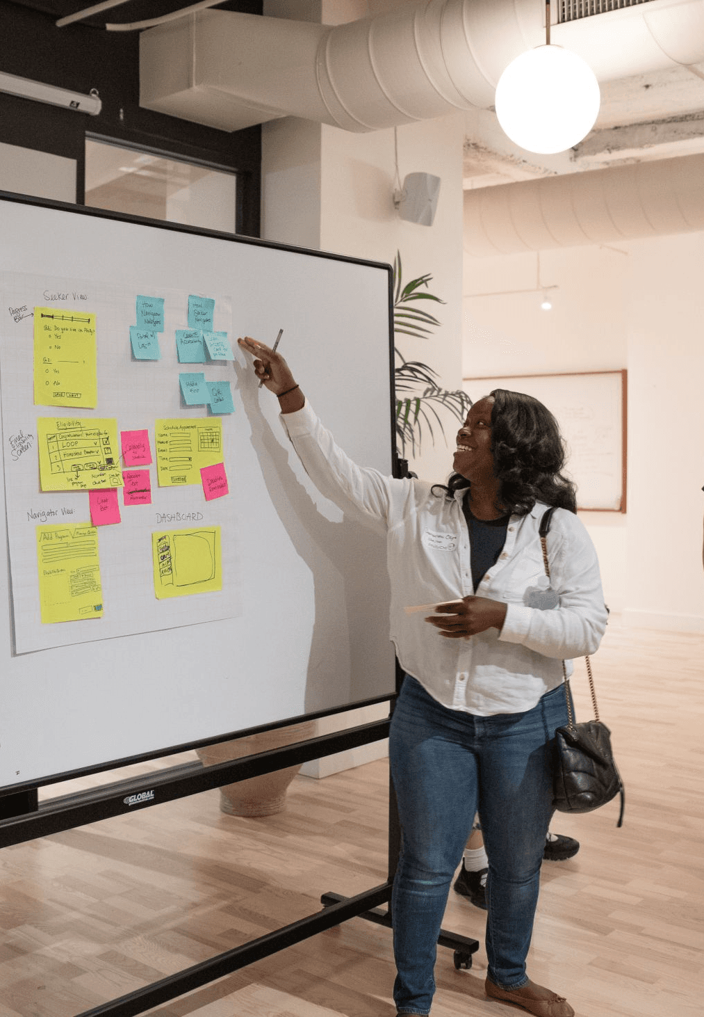 Samartha presenting at a design jam infront of a whiteboard.