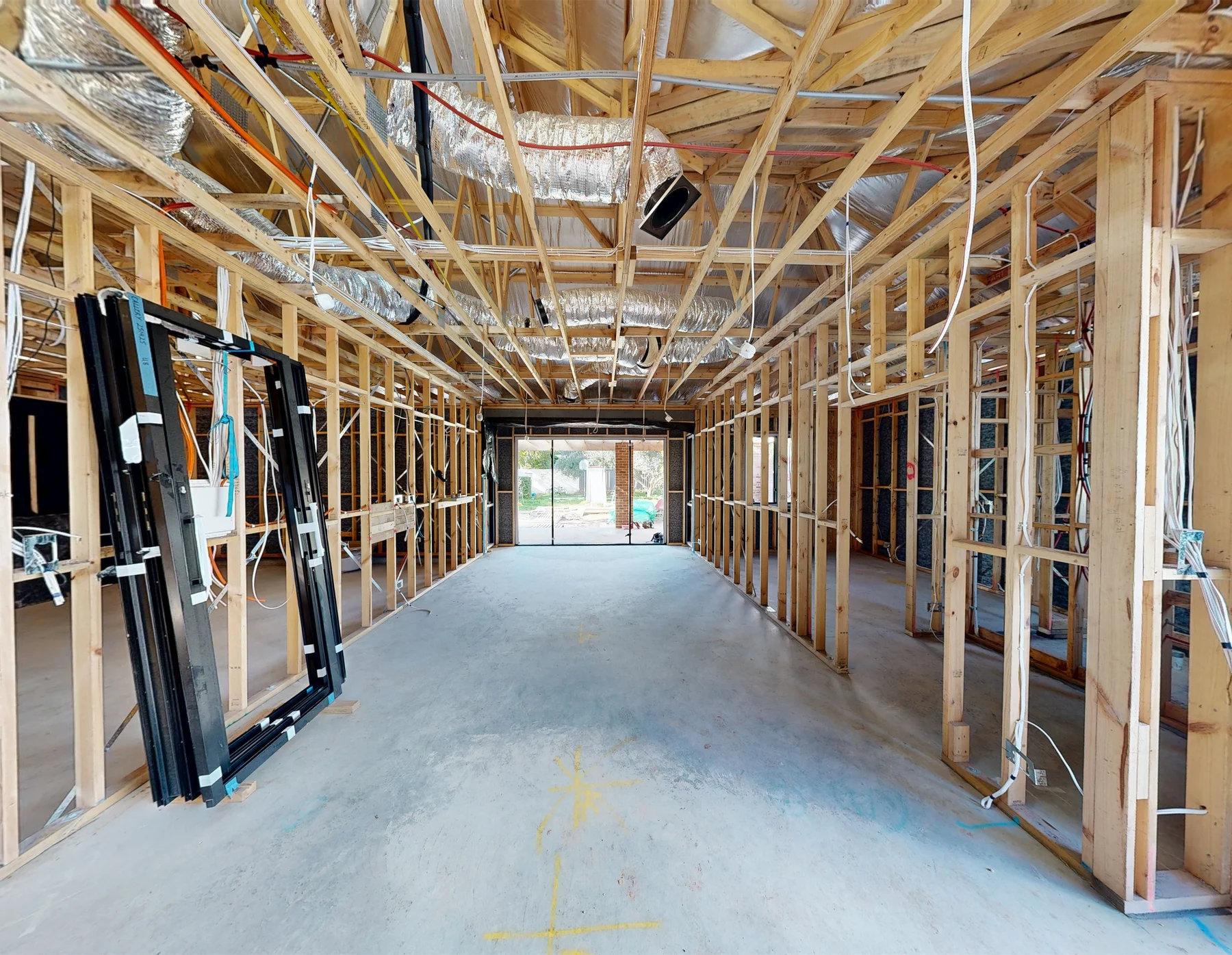 A pre-plaster construction site captured by ABM visual, showing exposed timber framing, ceiling ducting, electrical wiring and services before the walls are closed.