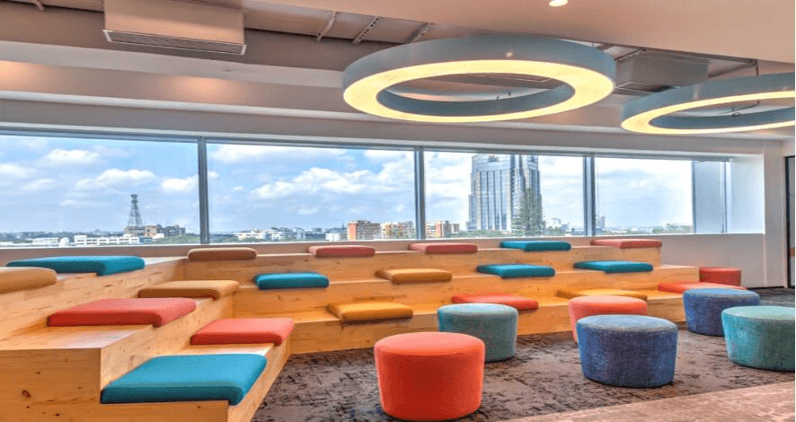 Vibrant Open Office floor with ergonomic desks, blue accents, and a communal meeting table in Boomi.
